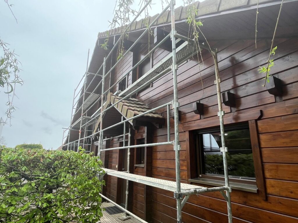 Maison à bardage bois en rénovation sous échafaudage dans le Haut-Doubs