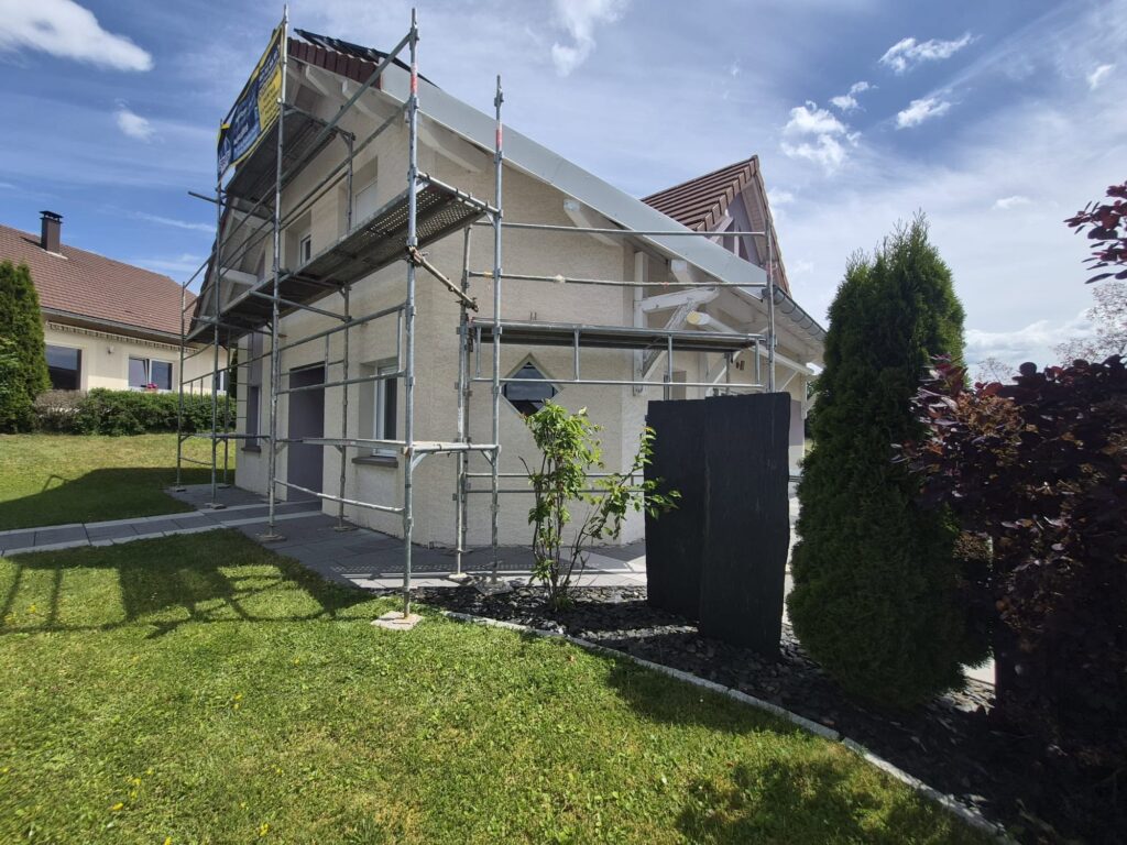 Façade de maison rénovée sous échafaudage dans le Haut-Doubs