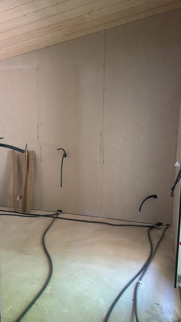Mur de plâtre neuf et câblage électrique au sol