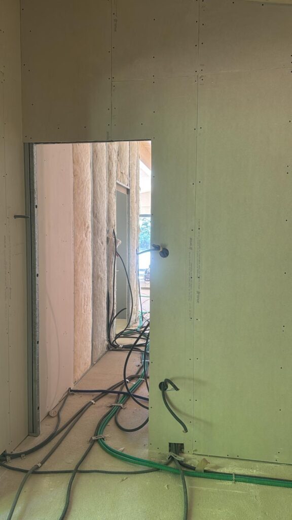 Pièce en travaux avec fenêtre lumineuse et gaines au sol