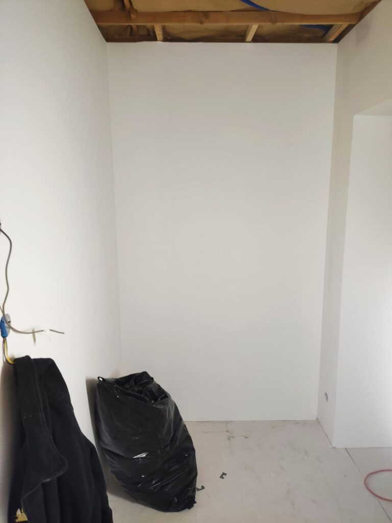 Pièce enduite en blanc avec sacs de chantier