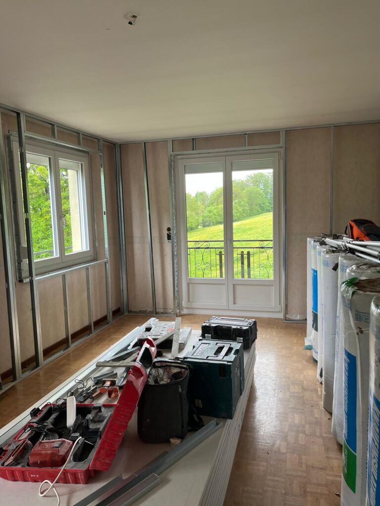 Pièce avec ossature de doublage, fenêtres et matériaux posés au sol
