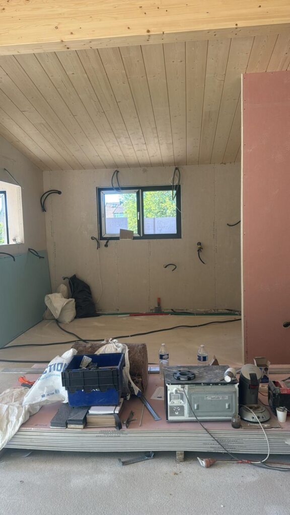 Pièce en travaux aux murs bicolores avec petite fenêtre