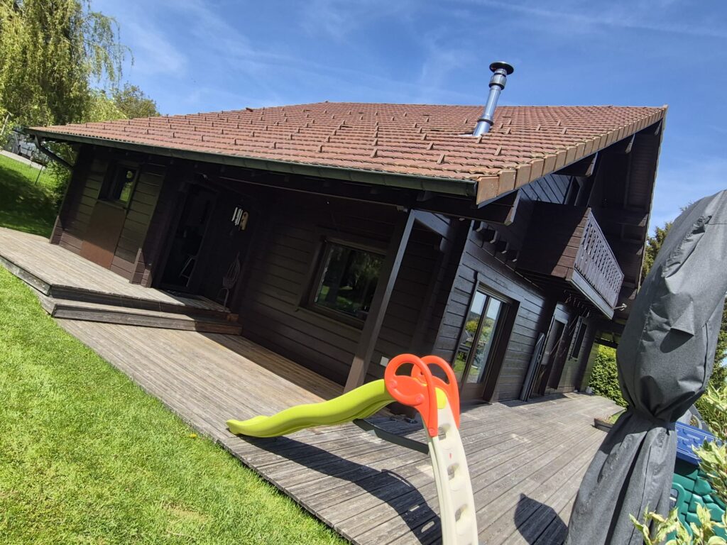 Chalet en bois sombre avec toiture en tuiles et terrasse avant rénovation extérieure