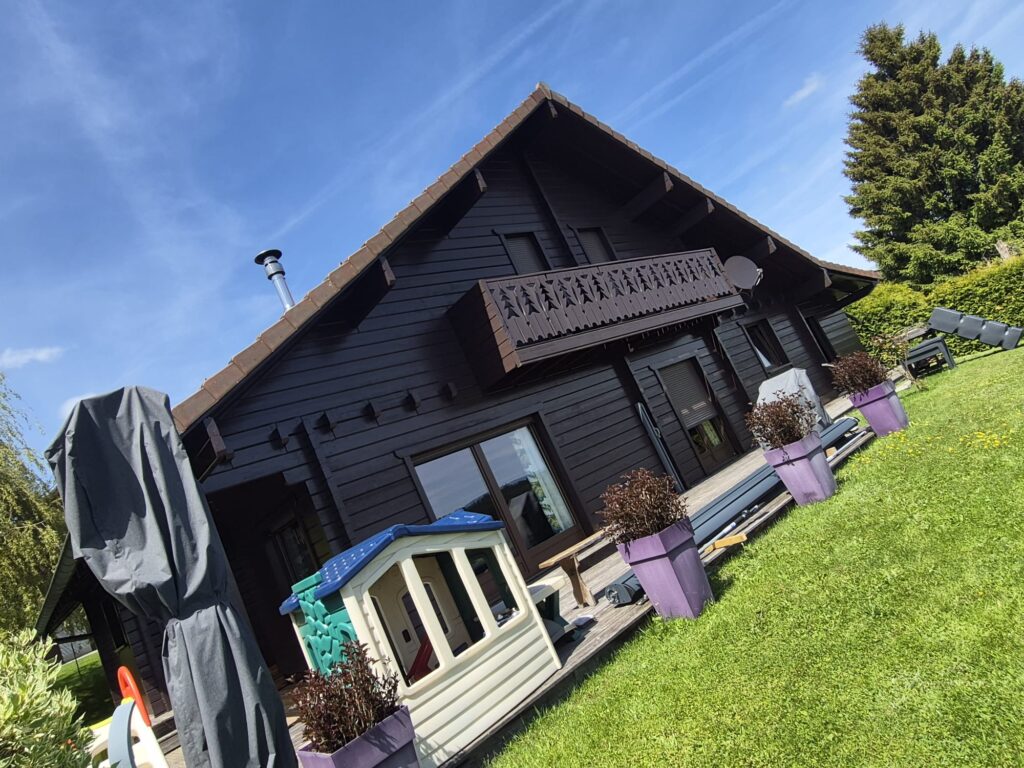 Chalet en bois vu depuis le jardin avec terrasse et plantes