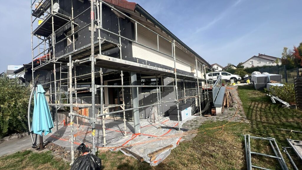 Isolation extérieure de façade : échafaudage le long d'une maison, parasol bleu