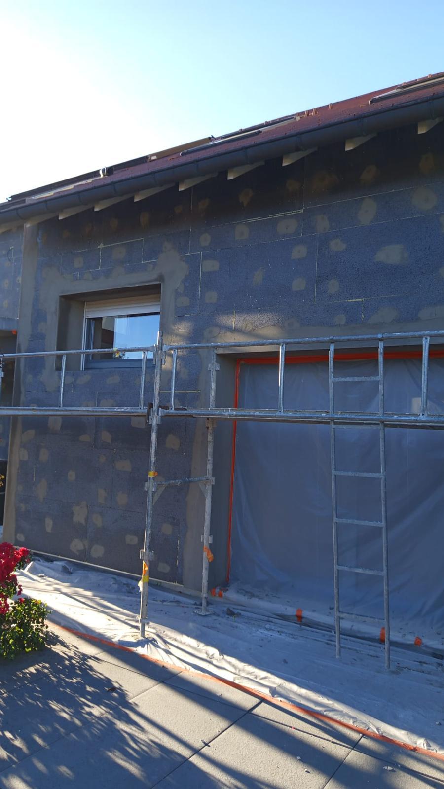 Isolation extérieure de façade : baie vitrée sous échafaudage et panneaux isolants