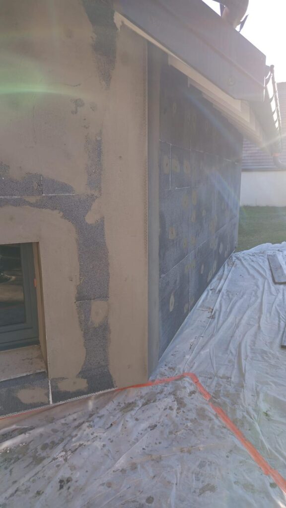 Isolation extérieure de façade : angle de mur avec bâche de protection