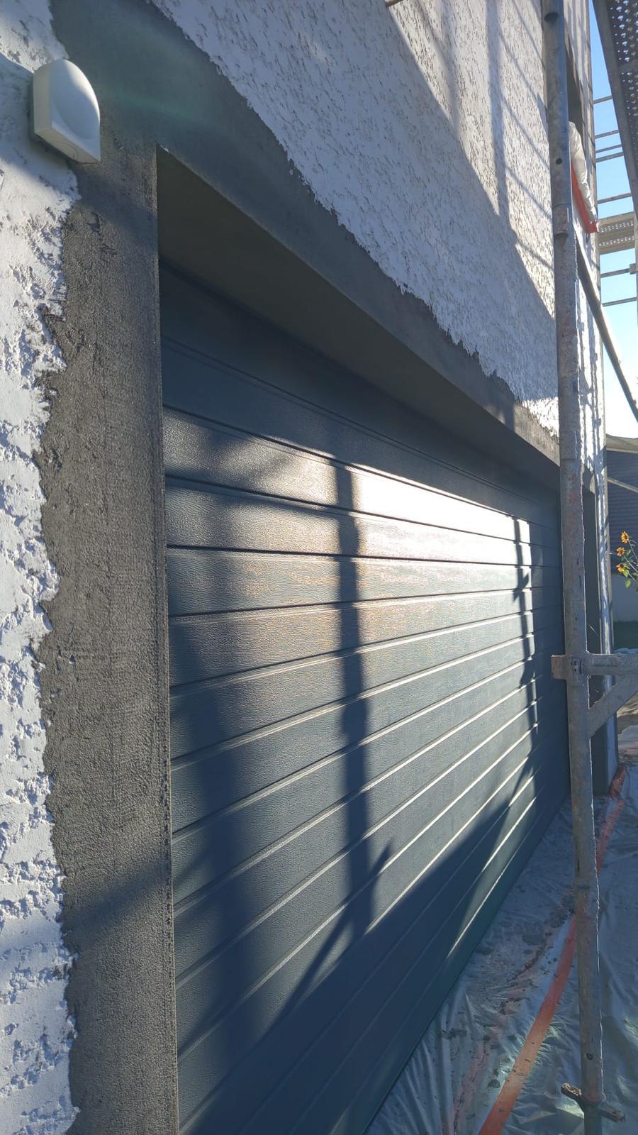 Isolation extérieure de façade : mur enduit près d'une porte de garage