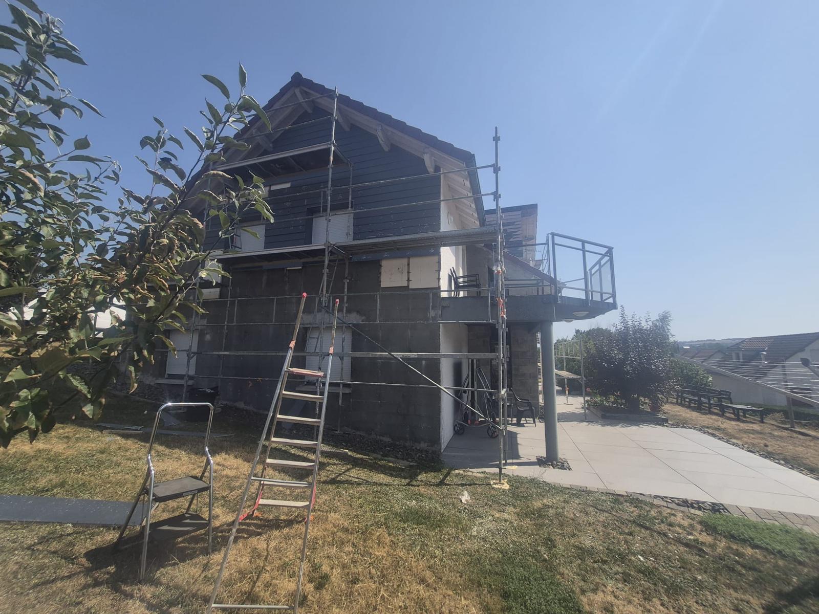 Isolation extérieure de façade : maison isolée avec balcon et échelle