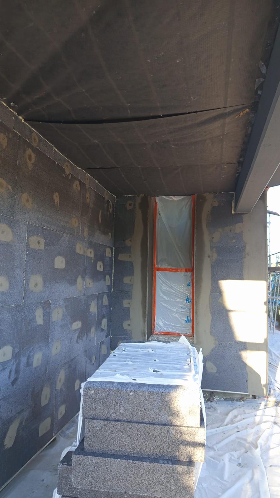 Isolation extérieure de façade : entrée et panneaux isolants avec protection de menuiserie